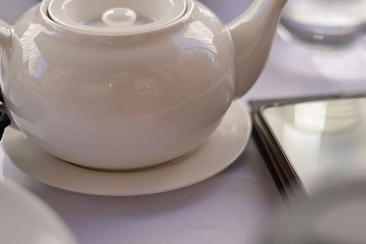 A plain white porcelain teapot on a table