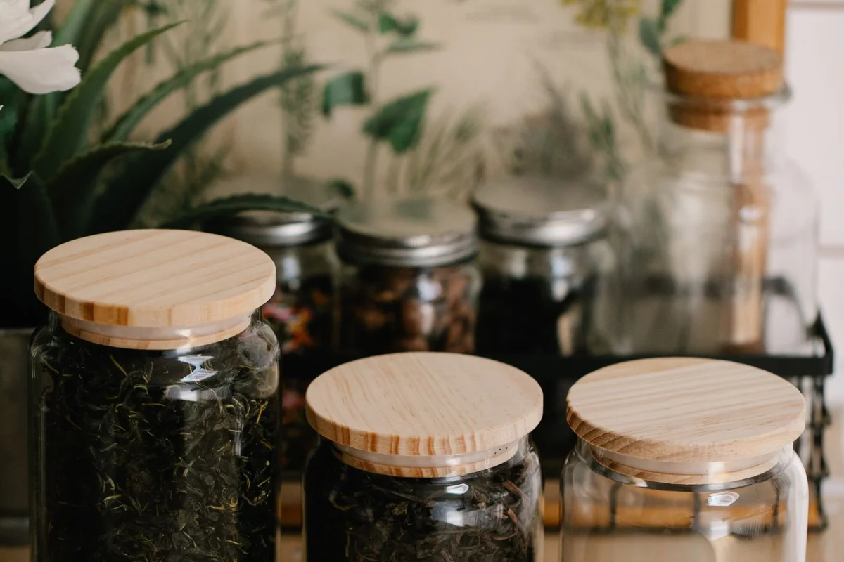 Dry tea and infusions in clear jars with wooden lids