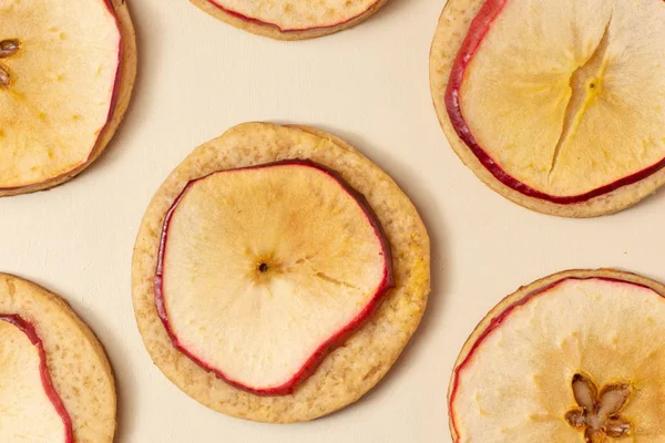 Thin dried apple slices on a pale surface