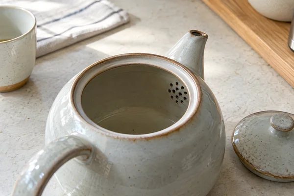 Inside view of a ceramic tea pot with small strainer holes at spout