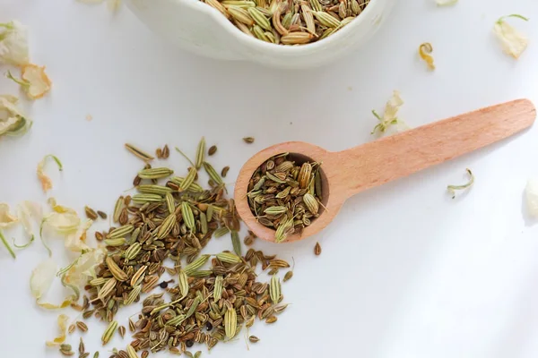 Ridged fennel seeds in a bowl and wooden spoon