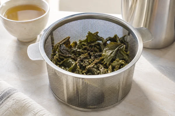 Expanded rolled oolong leaves inside a spacious stainless steel basket