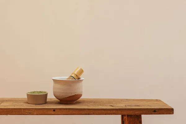 A wide matcha bowl with a bamboo whisk