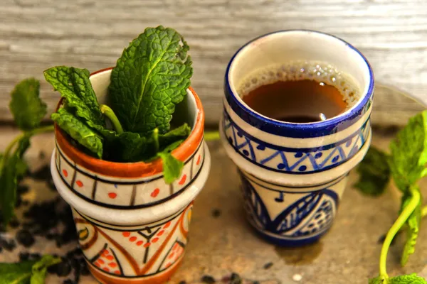 Moroccan mint tea and fresh mint in painted ceramic cups