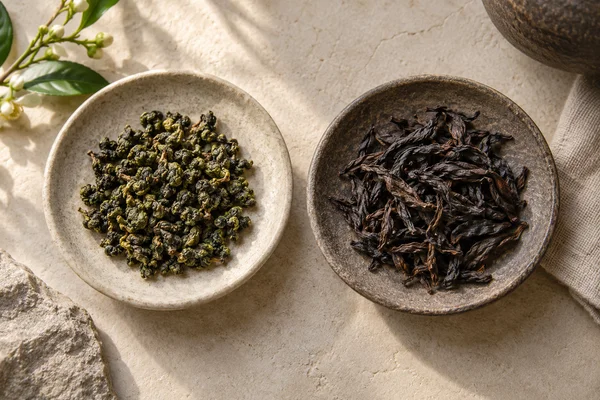 Green rolled oolong beside dark twisted roasted oolong leaves