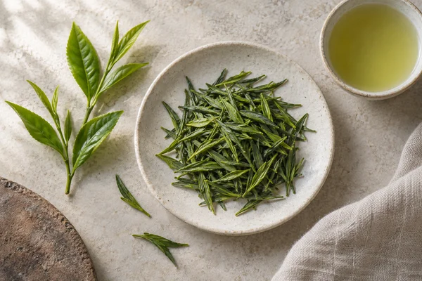 Fresh spring tea shoots beside newly processed green shincha leaves