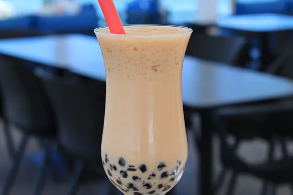Milk tea with dark tapioca pearls in a clear glass