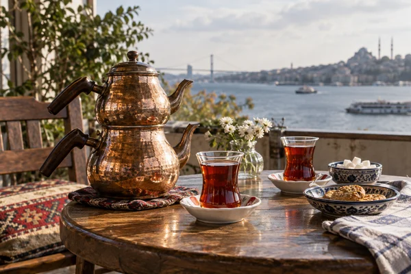 Stacked turkish double teapot with tea glasses on a small shared table
