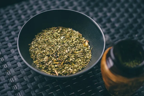 Chopped dried yerba mate leaves in a black bowl
